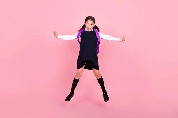 Full length body size photo schoolgirl jumping up with backpack smiling isolated pastel pink color background — Stock Photo, Image