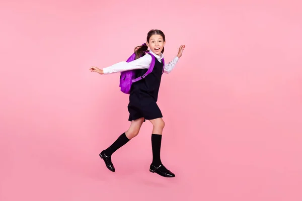 Full längd kropp storlek foto skolflicka hoppa kör på lektion på 1 September isolerad pastell rosa färg bakgrund — Stockfoto