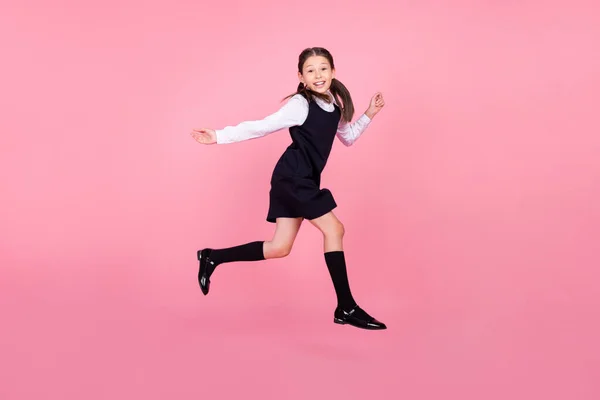 Full length body size photo schoolgirl jumping up smiling running on lesson isolated pastel pink color background — Stock Photo, Image