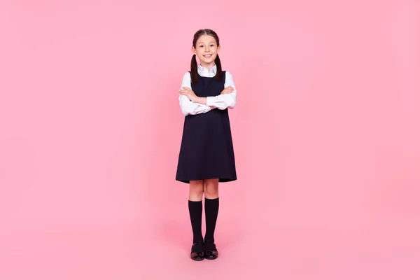 Foto de longitud completa de la niña de la escuela feliz sonrisa positiva confianza manos plegadas aisladas sobre fondo de color rosa —  Fotos de Stock