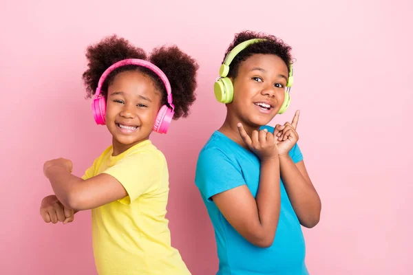 Retrato de dos amigos alegres atractivos amistad escuchar sonido bajo divertirse bailando aislado sobre fondo de color rosa —  Fotos de Stock