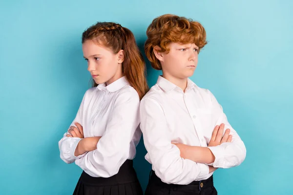 Retrato de dos atractivos niños sombríos y malhumorados conflicto brazos cruzados disputa aislado sobre fondo de color azul brillante — Foto de Stock