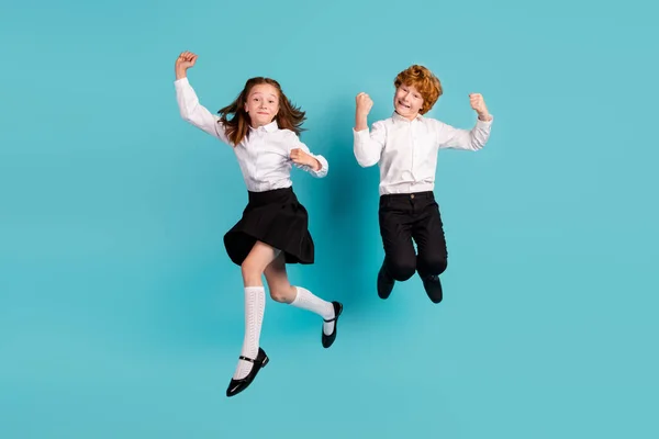 Ganzer Länge Körpergröße Ansicht von zwei fröhlichen Kindern springen Spaß isoliert über helle blaue Farbe Hintergrund — Stockfoto