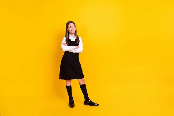 Full längd kropp storlek foto skolflicka i uniform ser tomt utrymme isolerad ljus gul färg bakgrund — Stockfoto