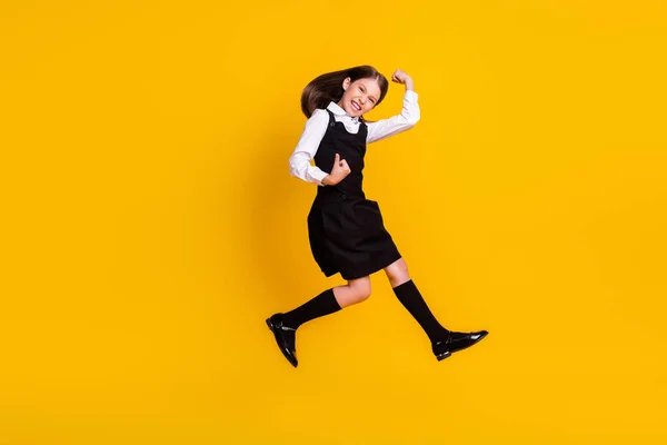 Pleine longueur corps taille photo écolière sautant geste comme gagnant heureux isolé vif fond de couleur jaune — Photo