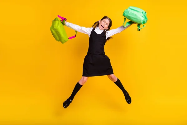 Comprimento total tamanho do corpo foto estudante saltando duas mochilas furioso furioso isolado cor amarela brilhante fundo — Fotografia de Stock