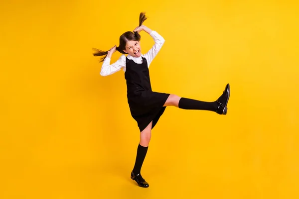 Foto de longitud completa de funky feliz niña positiva saltar funky sostener las manos colas aisladas en el fondo de color amarillo —  Fotos de Stock