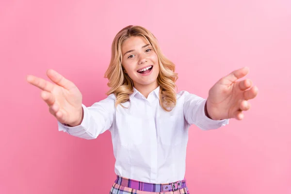 Фото збудженої смішної школярки, яка носить офіційне вбрання відкриті руки, готові обійняти вас, посміхаючись ізольований рожевий колір фону — стокове фото