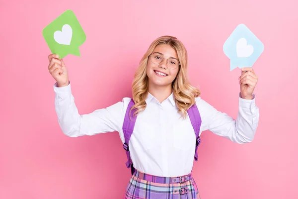 Retrato de una atractiva chica de pelo ondulado alegre sosteniendo papel como influencer bloguero de tarjetas aislado sobre un fondo de color pastel rosa — Foto de Stock