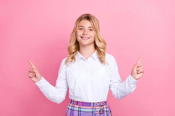 Porträt von attraktiven fröhlichen Mädchen zeigt Kopie leeren Leerraum Anzeige isoliert über rosa Pastellfarbe Hintergrund — Stockfoto