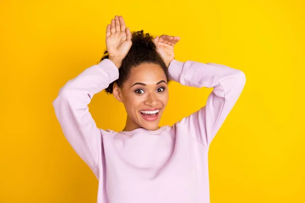 Foto av unga glada positiva afro amerikanska funky flicka hålla händer kanin öron isolerade på gul färg bakgrund — Stockfoto