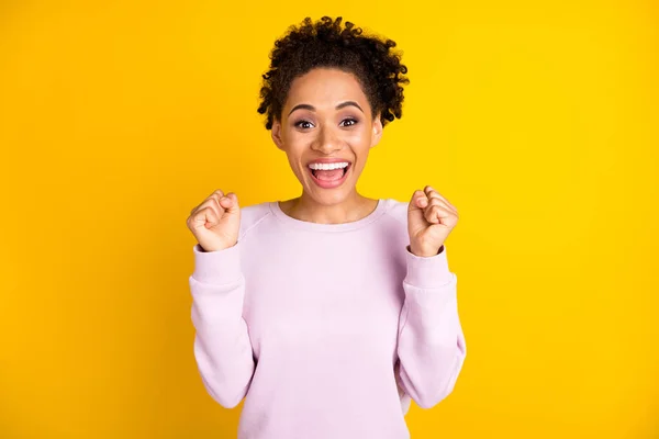 Foto de la joven feliz mujer de piel oscura ganadora celebrar emocionado buen humor aislado en el fondo de color amarillo —  Fotos de Stock