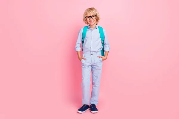 귀여운 남학생의 사진은 파란 셔츠를 입고 배낭을 메고 핑크 색 배경을 웃고 있다. — 스톡 사진