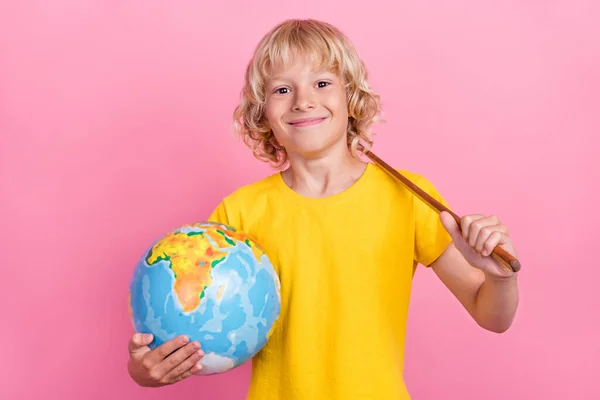 Zdjęcie młodego chłopca szkoły szczęśliwy pozytywny uśmiech trzymać globe kij edukacji izolowane na różowy kolor tła — Zdjęcie stockowe