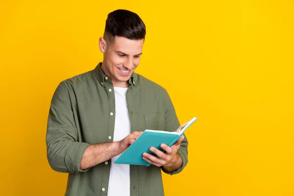 Retrato de atraente alegre inteligente inteligente focado cara ler livro interessante isolado sobre cor amarela brilhante fundo — Fotografia de Stock