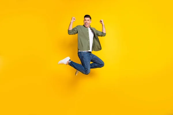 Ganzkörpergröße Foto Kerl springen gestikulierend wie Sieger isoliert lebendige gelbe Farbe Hintergrund — Stockfoto