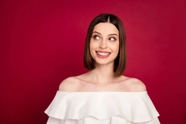 Foto portret mooi brunette op zoek lege ruimte glimlachen geïsoleerde rode kleur achtergrond — Stockfoto