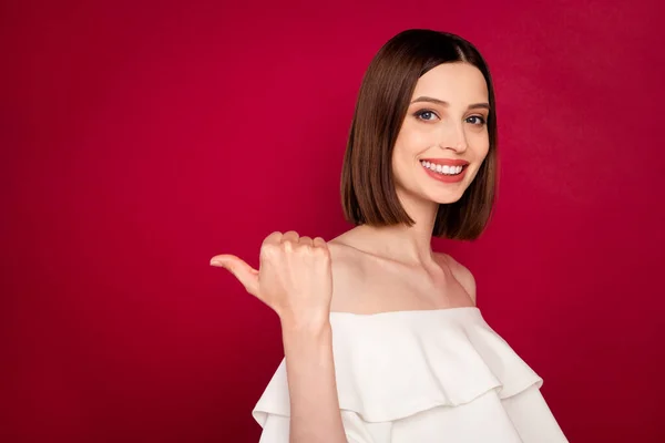 Photo portrait pretty brunette showing thumb blank space smiling isolated red color background — Stock Photo, Image
