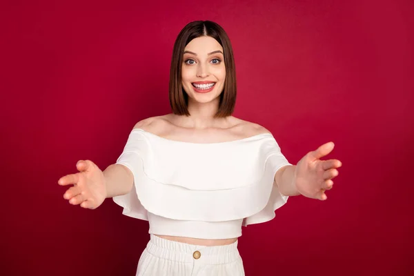 Foto di giovane ragazza felice sorriso positivo braccia aperte abbraccio coccole benvenuto invitare isolato su sfondo di colore rosso — Foto Stock