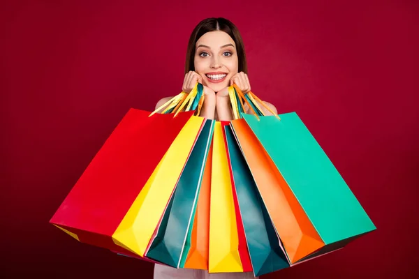 Neşeli genç kızın fotoğrafı mutlu bir gülümseme mağazası satış mağazası kırmızı arka planda izole edilmiş renkli çantalar. — Stok fotoğraf