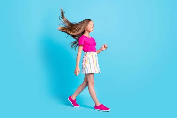 Perfil de corpo inteiro foto lateral da menina alegre feliz andar vazio espaço sonho mosca cabelo isolado no fundo de cor azul — Fotografia de Stock
