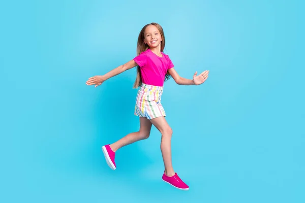 Full length photo of happy positive young little girl jump up walk empty space sale isolated blue color background — Stock Photo, Image