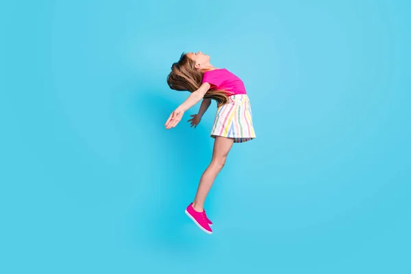 Foto lateral de perfil de longitud completa de la alegre niña feliz saltar espacio vacío aislado en el fondo de color azul —  Fotos de Stock