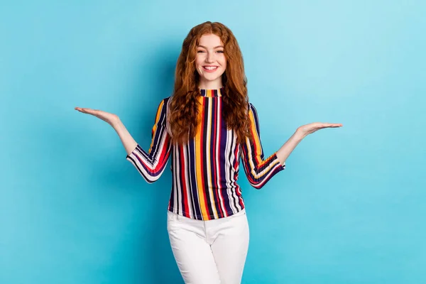 Foto van koele gember kapsel millennial dame houden lege ruimte dragen kleurrijke shirt geïsoleerd op blauwe kleur achtergrond — Stockfoto