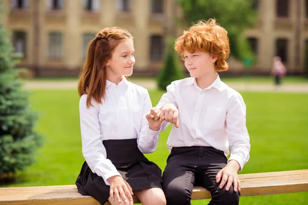 两个最要好的红头发同学坐在长椅上，手握小指，身穿白衬衫，站在室外 — 图库照片