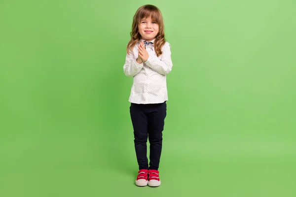 Ganzkörperfoto von kleinen flippigen Mädchen halten Hände tragen weiße Hemdhosen Turnschuhe isoliert auf grünem Hintergrund — Stockfoto