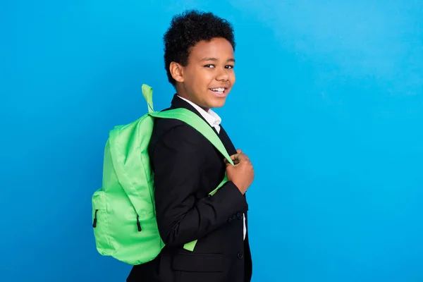 Foto van vrolijke vrolijke positieve kleine jongen dragen rugzak goed humeur geïsoleerd op pastel blauwe kleur achtergrond — Stockfoto