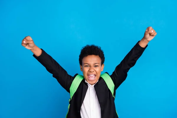 Foto de alegre jovem feliz menino positivo levantar punhos vencedor escola de bom humor isolado no fundo de cor azul — Fotografia de Stock
