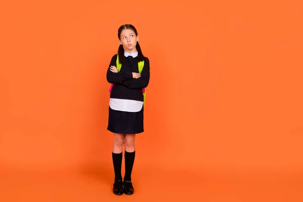 Foto de cuerpo completo de la niña de mente soñadora mirar vacío espacio manos cruzadas bolsa aislada sobre fondo de color naranja —  Fotos de Stock