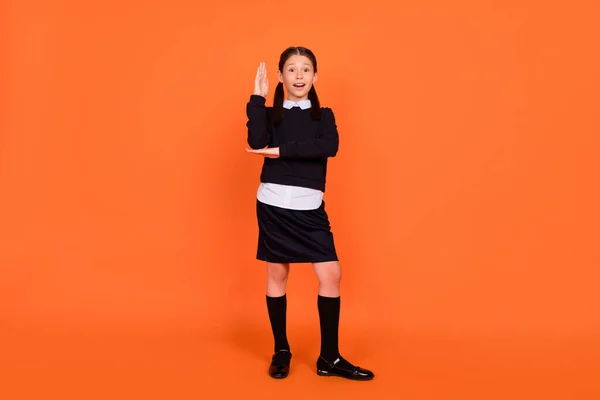 Foto de cuerpo completo de la niña de la escuela feliz sonrisa positiva aumento mano respuesta lección aislado sobre fondo de color naranja —  Fotos de Stock