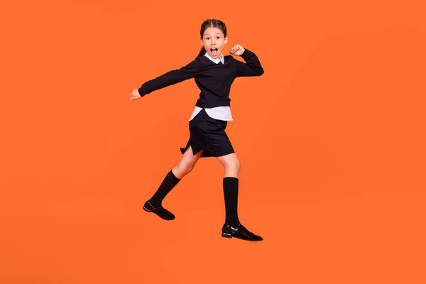 Full längd foto av förvånad chockad liten flicka hoppa upp gå gå tomt utrymme försäljning isolerad på orange färg bakgrund — Stockfoto