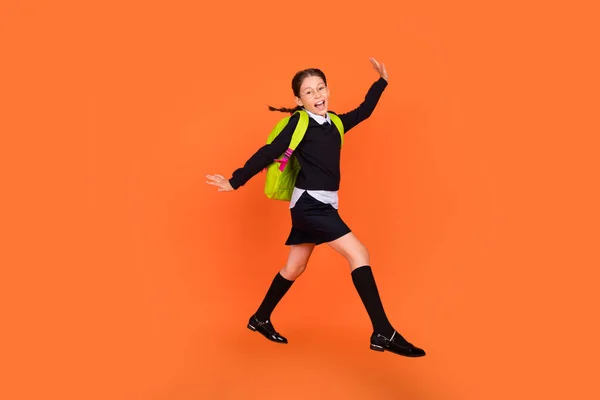 Volledige lengte lichaam grootte uitzicht van mooie vrij funky vrolijke schoolmeisje springen lopen geïsoleerd over helder oranje kleur achtergrond — Stockfoto