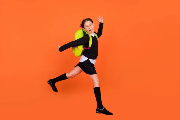 Perfil de comprimento total foto lateral da menina da escola feliz sorriso positivo pular corrida 1-setembro isolado sobre fundo cor de laranja — Fotografia de Stock