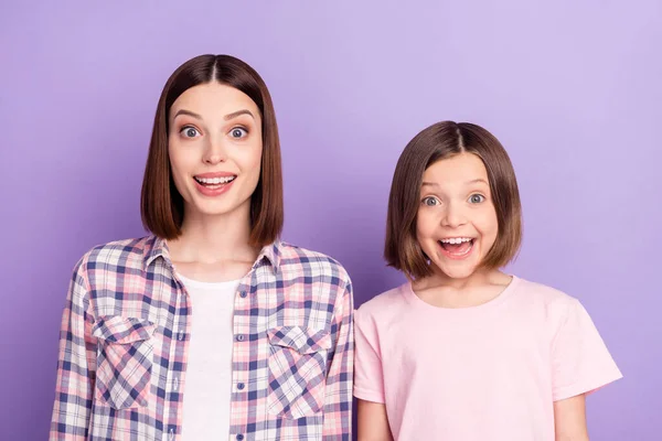 Porträtt av två attraktiva glada förvånade flickor bästa vänner goda nyheter reaktion isolerad över lila violett färg bakgrund — Stockfoto