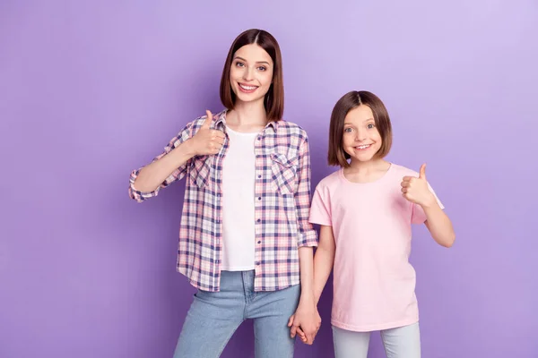 Porträtt av två attraktiva glada flickor vänner visar tummen annons isolerad över lila violett färg bakgrund — Stockfoto