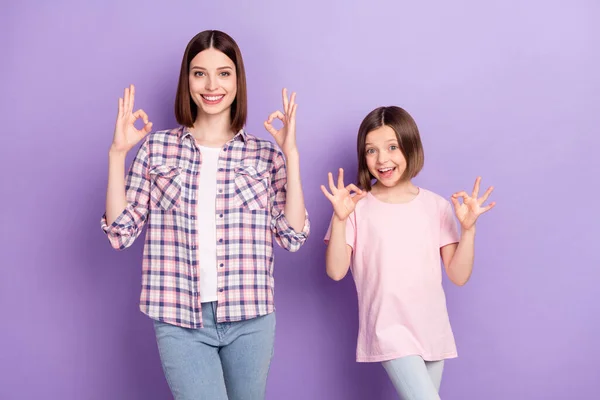 Porträtt av två attraktiva glada flickor visar ok-tecken annons isolerad över lila violett färg bakgrund — Stockfoto
