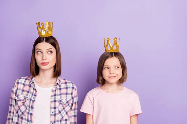 왕관을 쓴 매력적 인 정신을 가진 두 소녀가 보라색 배경 위에 격리 된 복사본 공간을 바라보고 있는 모습 — 스톡 사진
