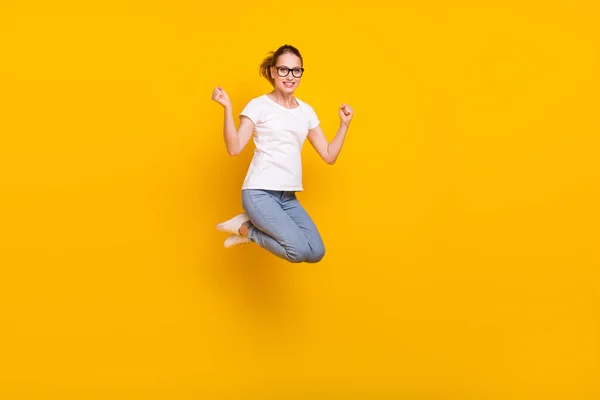 フルボディ写真の若いです幸せな女性ジャンプアップファイスト受賞者祝います絶縁上の黄色の色の背景 — ストック写真