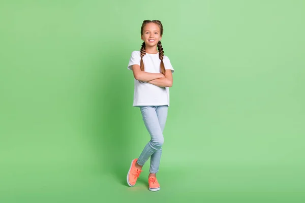 Foto lengkap ukuran tubuh gadis kecil tersenyum dengan bersilang tangan dengan pakaian bergaya terisolasi latar belakang warna hijau pastel — Stok Foto