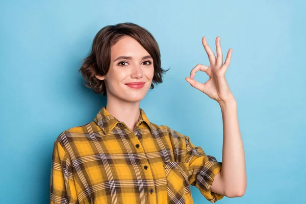 Foto de menina confiável olhar câmera mostrar okey sinal aprovar solução desgaste xadrez camisa isolado azul cor fundo — Fotografia de Stock