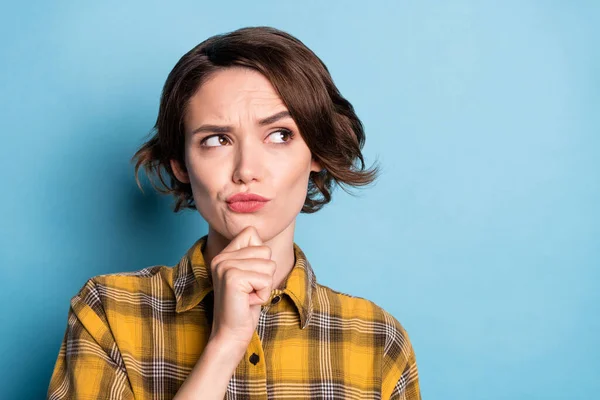 Foto de mentalidad creativa dudosa chica dedo barbilla mirada espacio vacío desgaste camisa a cuadros aislado color azul fondo —  Fotos de Stock