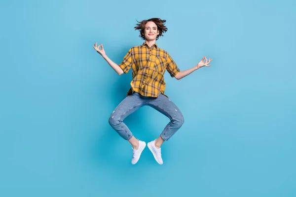 Foto de la señora tranquila salto meditar disfrutar de vuelo usar camisa a cuadros jeans zapatos aislados de color azul de fondo — Foto de Stock