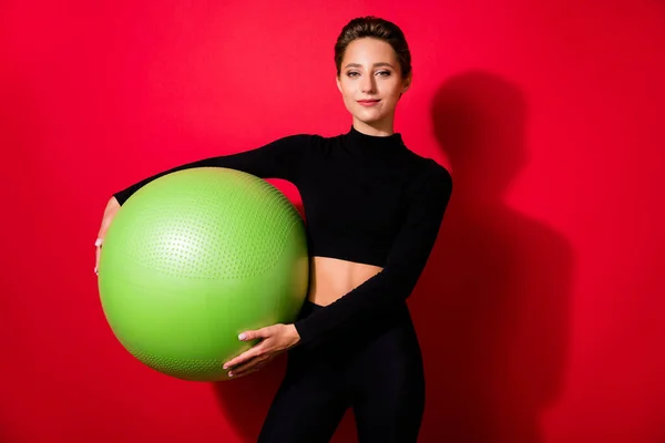 Portré vonzó vidám lány gazdaság fitball kardió edzés zsírégetés elszigetelt felett élénk piros háttér — Stock Fotó