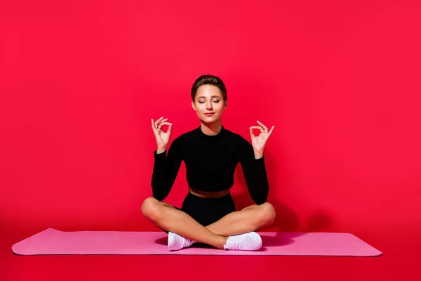 Foto de la calma de ensueño tranquilo dama armonía meditación tiempo desgaste negro ropa deportiva aislado color rojo fondo —  Fotos de Stock