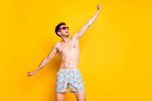 Ritratto di attraente ragazzo funky sognante allegro senza camicia che si diverte località di mare isolato su sfondo di colore giallo brillante — Foto Stock