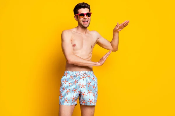 Foto von ziemlich entzückenden jungen Mann nackten Oberkörper tragen dunkle Brille tanzen lächelnd isoliert gelbe Farbe Hintergrund — Stockfoto